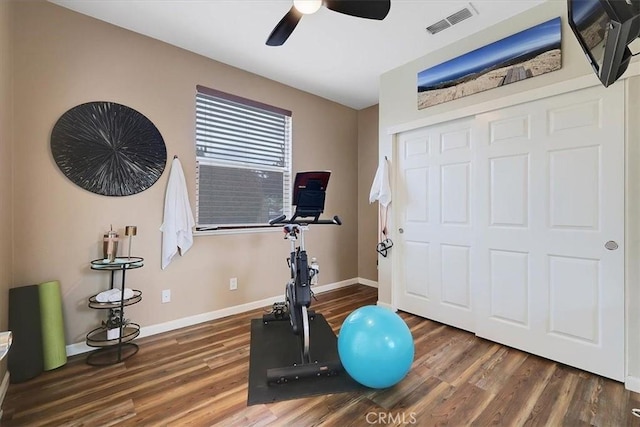 exercise room with wood finished floors, baseboards, a ceiling fan, and visible vents