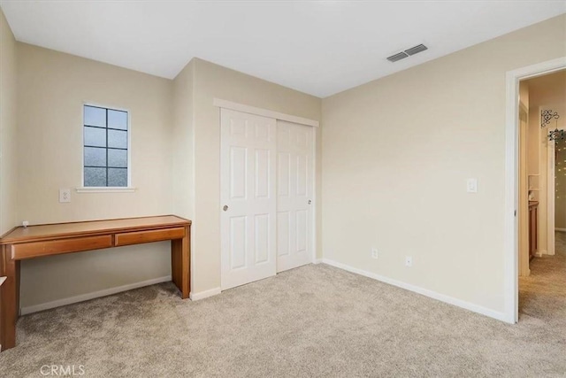 unfurnished bedroom with visible vents, baseboards, a closet, and carpet floors