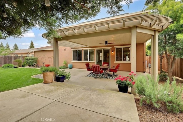 rear view of house featuring a yard, a patio area, stucco siding, and fence