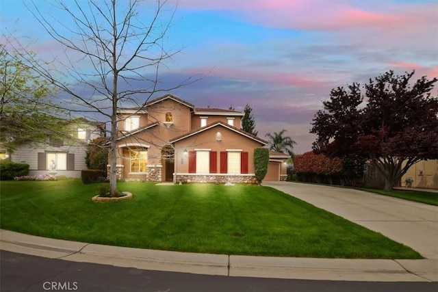 view of front of home featuring a front yard, driveway, stucco siding, and stone siding