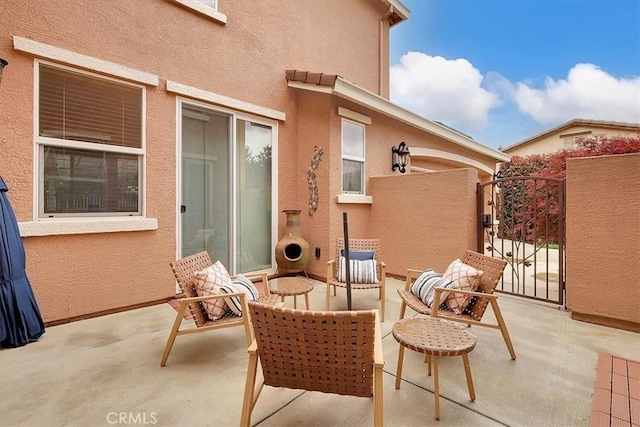 view of patio with outdoor lounge area and a gate