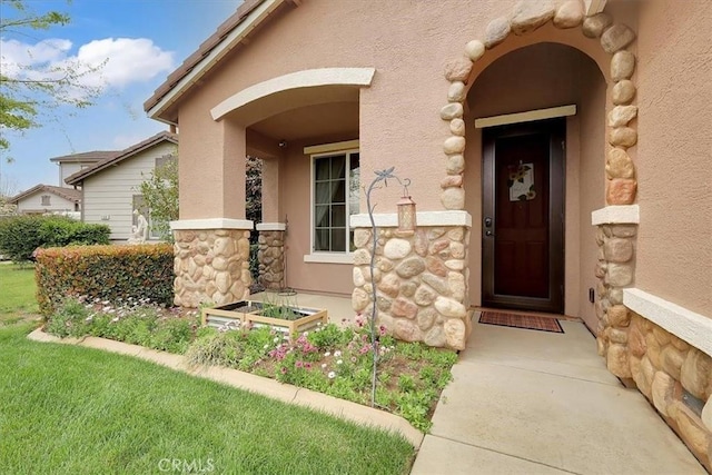 entrance to property with stucco siding and stone siding