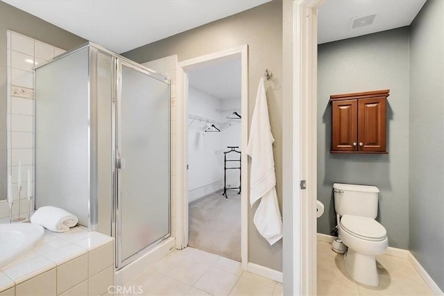 bathroom with visible vents, a bath, a walk in closet, tile patterned floors, and a stall shower