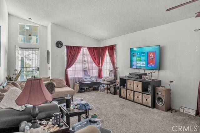 living room with ceiling fan, vaulted ceiling, and carpet floors