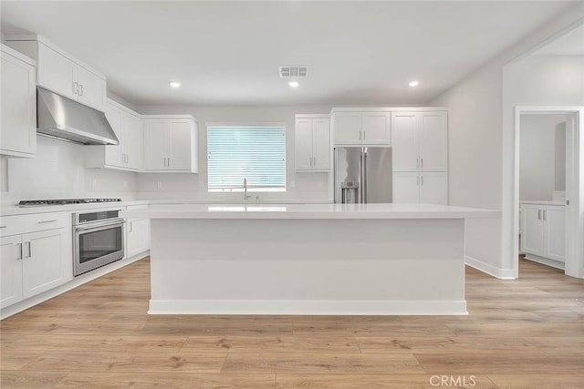 6 Crown Point Dr, Rancho Mission Viejo, CA 92694 - kitchen with a center island, light countertops, white cabinets, under cabinet range hood, and appliances with stainless steel finishes