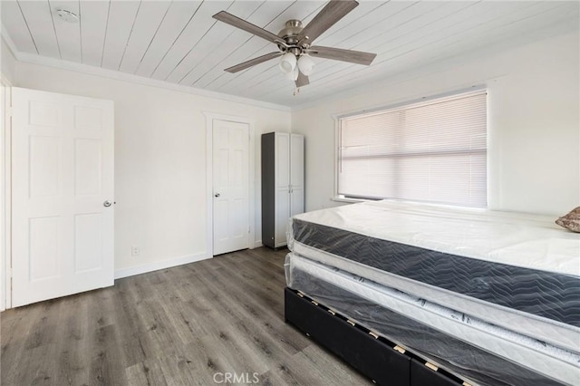 unfurnished bedroom featuring a ceiling fan, wood finished floors, ornamental molding, and wooden ceiling