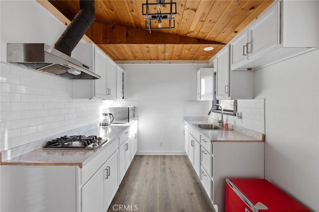 kitchen featuring wooden ceiling, a sink, light countertops, stainless steel gas stovetop, and light wood-style flooring