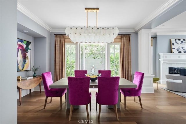 dining space with ornate columns, ornamental molding, and wood finished floors