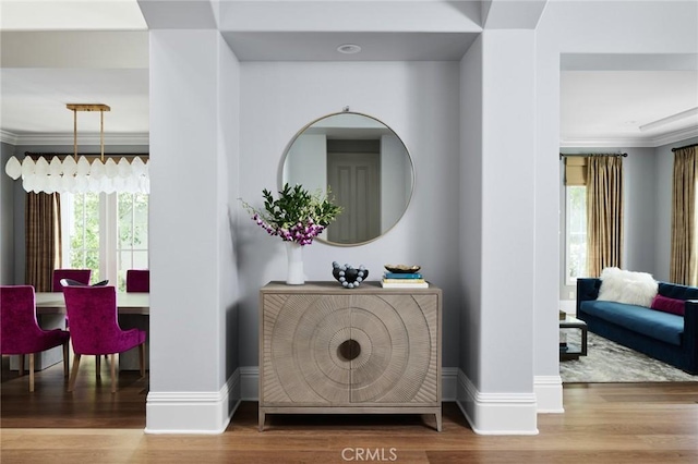interior space with crown molding, wood finished floors, and baseboards