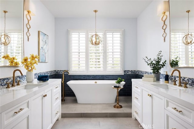 full bathroom with a chandelier, a sink, and plenty of natural light