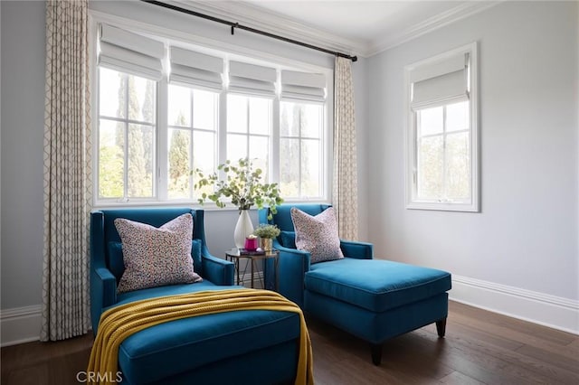 living area with crown molding, wood finished floors, and baseboards