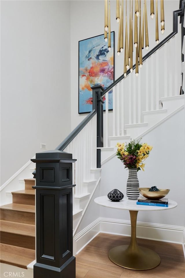 stairway featuring baseboards and wood finished floors