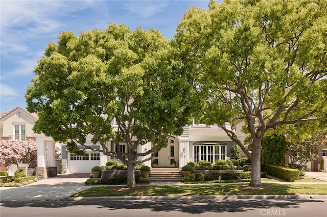 view of property hidden behind natural elements with driveway