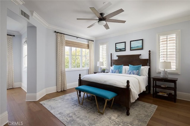 bedroom featuring baseboards, crown molding, a ceiling fan, visible vents, and wood finished floors