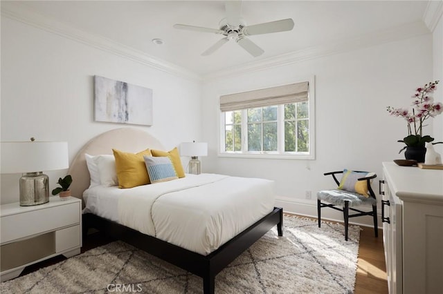 bedroom with a ceiling fan, baseboards, crown molding, and wood finished floors