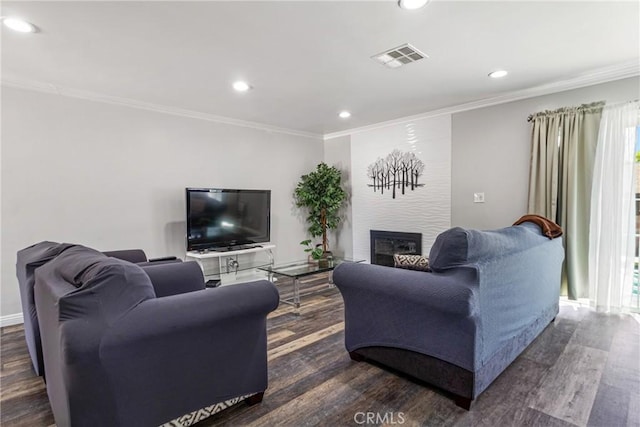 living room featuring visible vents, ornamental molding, dark wood finished floors, recessed lighting, and a large fireplace