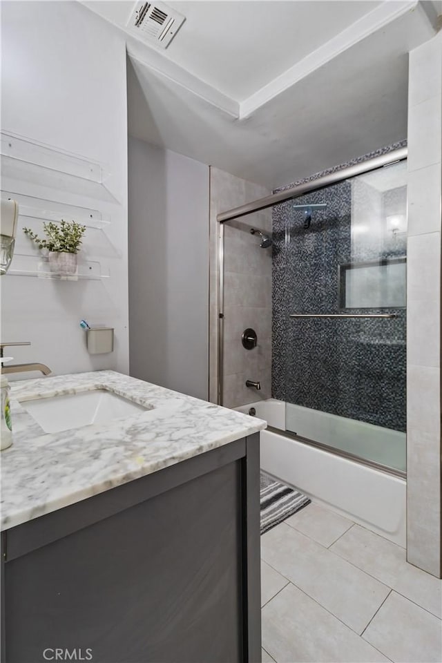 full bathroom featuring tile patterned floors, vanity, visible vents, and enclosed tub / shower combo