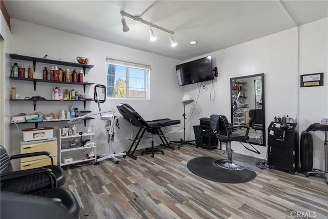 workout room featuring track lighting and wood finished floors