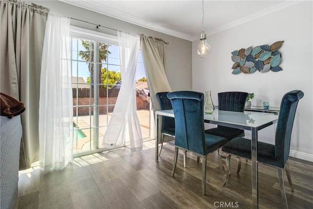 dining space with crown molding, wood finished floors, and baseboards