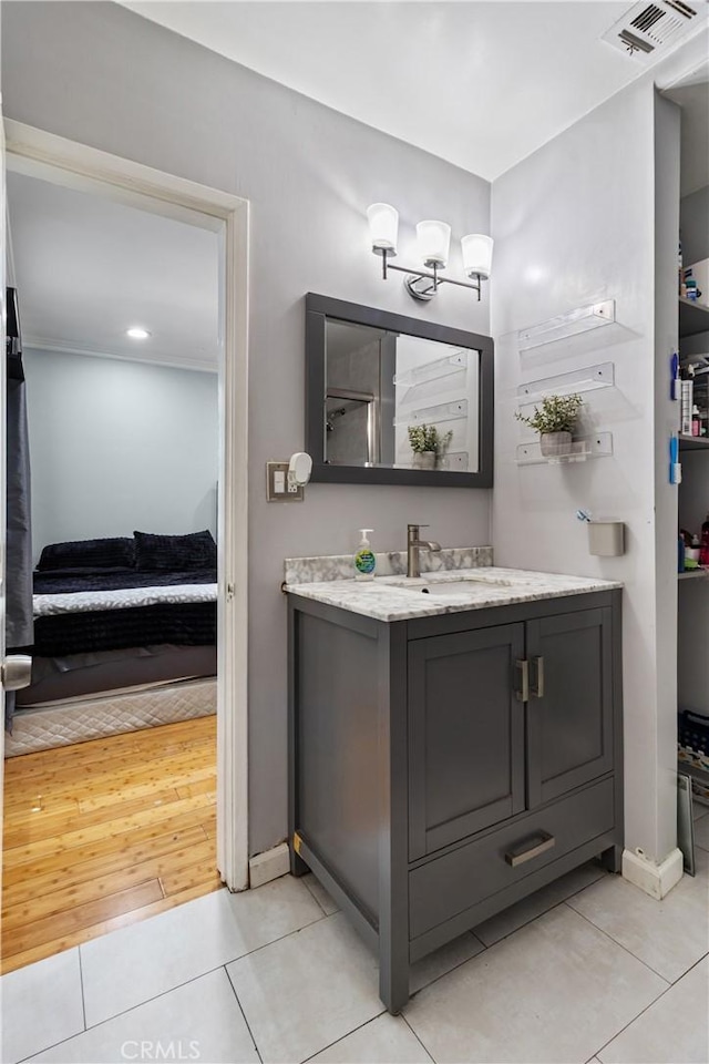 bathroom featuring visible vents, baseboards, ensuite bath, vanity, and tile patterned flooring