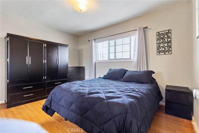 bedroom featuring baseboards and light wood-style floors