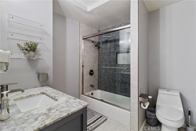 bathroom featuring tile patterned floors, bath / shower combo with glass door, vanity, and toilet