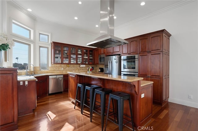 619 10th St, Hermosa Beach, CA 90254 - kitchen featuring glass insert cabinets, appliances with stainless steel finishes, wood finished floors, island range hood, and a kitchen island