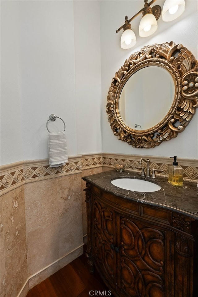 619 10th St, Hermosa Beach, CA 90254 - bathroom featuring tile walls, wood finished floors, vanity, and a wainscoted wall