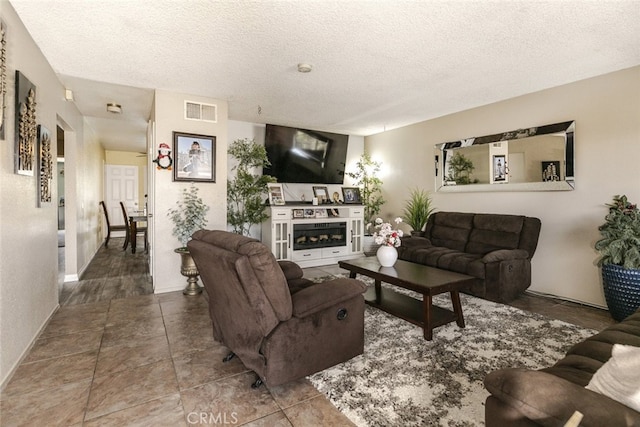 610 Woodington Dr, Lancaster, CA 93535 - living room with a textured ceiling, a glass covered fireplace, and baseboards