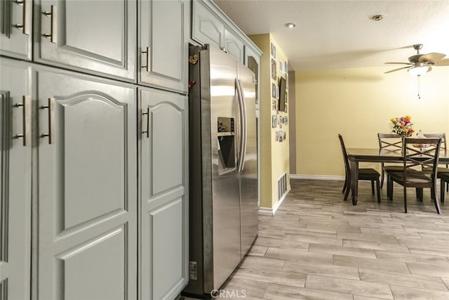 610 Woodington Dr, Lancaster, CA 93535 - kitchen with stainless steel fridge, ceiling fan, a textured ceiling, light wood finished floors, and baseboards