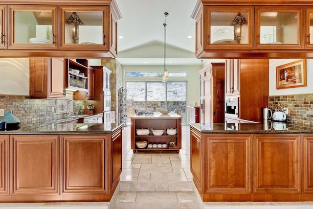 11558 Creek Rd, Poway, CA 92064 - kitchen with a peninsula, dark stone counters, tasteful backsplash, brown cabinets, and vaulted ceiling