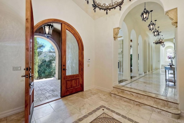 11558 Creek Rd, Poway, CA 92064 - foyer entrance with a chandelier, arched walkways, inlaid floor details, and marble tiled flooring