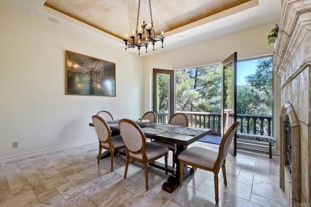 11558 Creek Rd, Poway, CA 92064 - dining space featuring a tray ceiling, a chandelier, and stone tile flooring