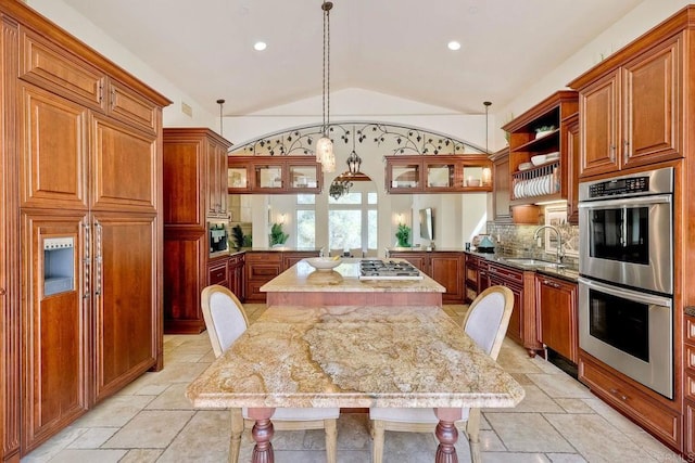 11558 Creek Rd, Poway, CA 92064 - kitchen with stainless steel appliances, lofted ceiling, stone tile floors, a peninsula, and a center island