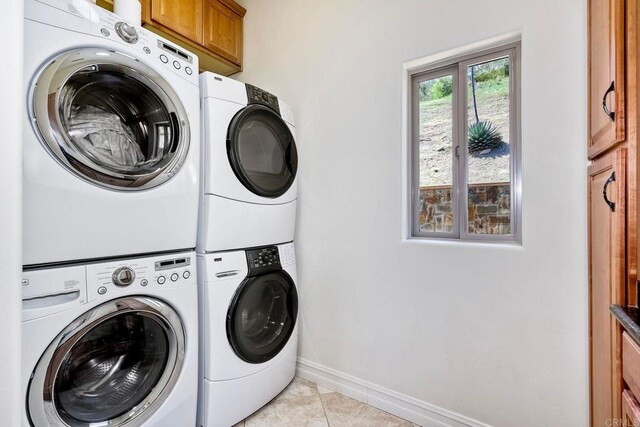 11558 Creek Rd, Poway, CA 92064 - laundry room with cabinet space, stacked washer / dryer, and light tile patterned floors