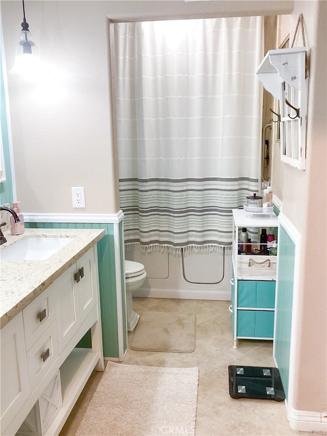 23796 Corte Picante, Murrieta, CA 92562 - bathroom featuring shower / tub combo, toilet, vanity, a wainscoted wall, and tile patterned flooring