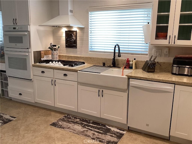 23796 Corte Picante, Murrieta, CA 92562 - kitchen featuring white appliances, white cabinetry, wall chimney exhaust hood, decorative backsplash, and a sink