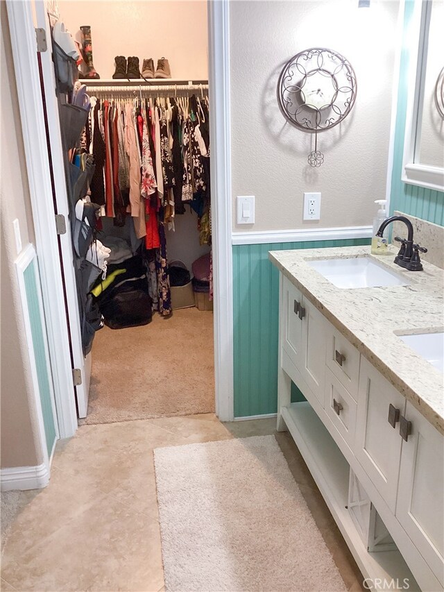 23796 Corte Picante, Murrieta, CA 92562 - full bathroom featuring double vanity, a sink, a spacious closet, and a wainscoted wall