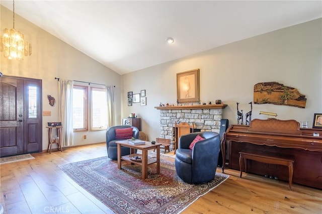 7191 Slater Ave, Huntington Beach, CA 92647 - living area with high vaulted ceiling, an inviting chandelier, hardwood / wood-style flooring, and a fireplace