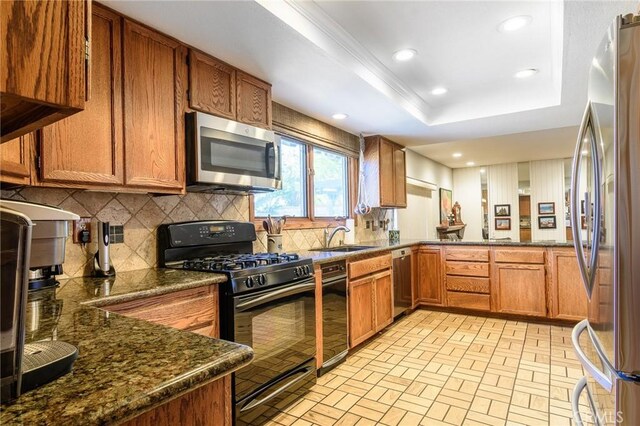 7191 Slater Ave, Huntington Beach, CA 92647 - kitchen featuring a sink, brown cabinetry, appliances with stainless steel finishes, and decorative backsplash