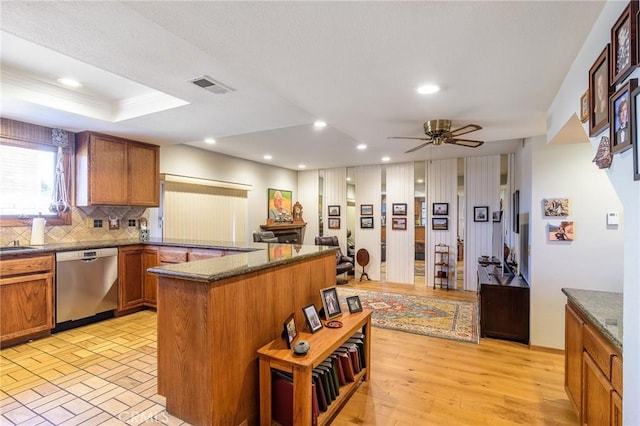 7191 Slater Ave, Huntington Beach, CA 92647 - kitchen with stainless steel dishwasher, ceiling fan, visible vents, brown cabinets, and decorative backsplash