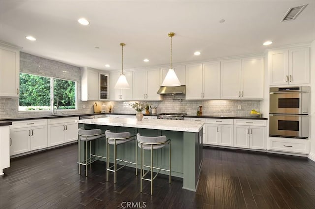 kitchen featuring double oven, visible vents, white cabinetry, a sink, and dark wood-style flooring