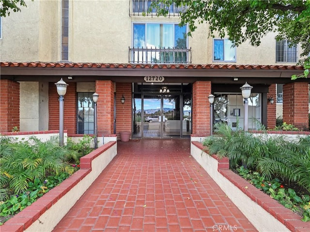 12720 Burbank Blvd Unit 323, Valley Village, CA 91607 - doorway to property with stucco siding, a porch, and brick siding