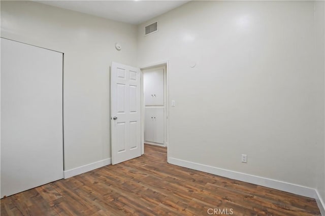 empty room featuring visible vents, baseboards, and wood finished floors