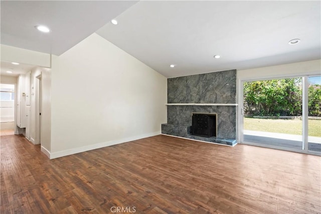 unfurnished living room featuring wood finished floors, a fireplace, baseboards, and recessed lighting