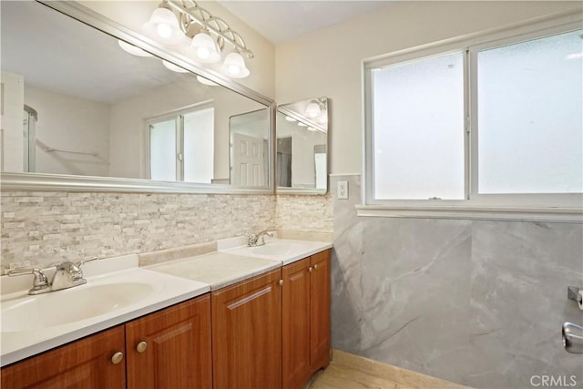 full bath featuring a sink, tasteful backsplash, and double vanity