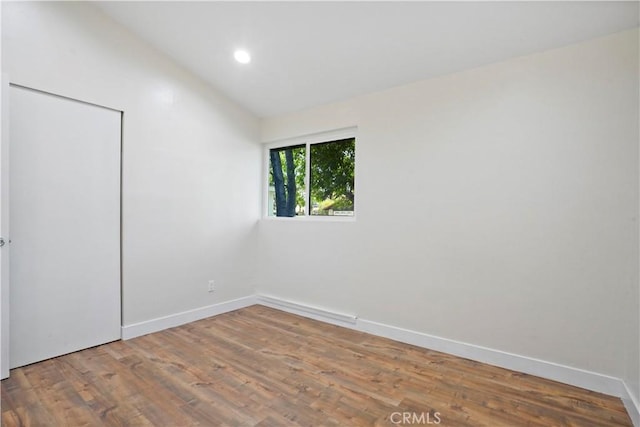 unfurnished room with recessed lighting, baseboards, and wood finished floors