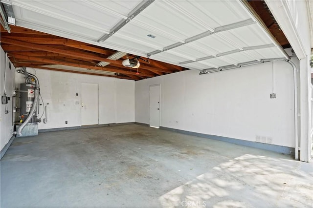 garage featuring water heater, visible vents, and a garage door opener