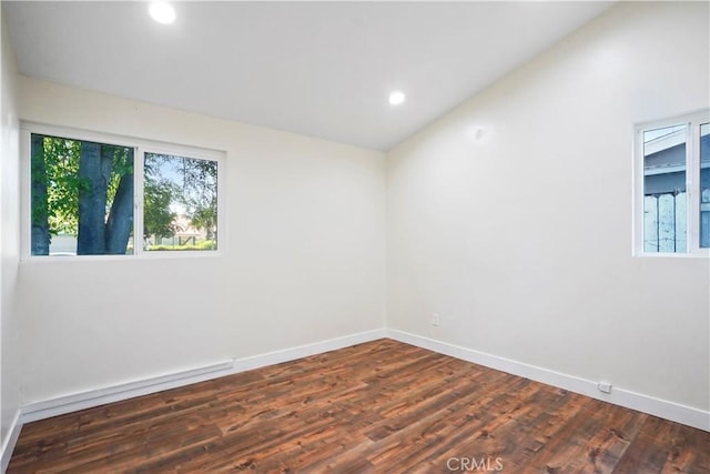 unfurnished room with dark wood-style flooring, baseboards, recessed lighting, and lofted ceiling
