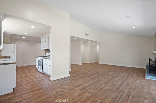 kitchen featuring white cabinets, white appliances, visible vents, and wood finished floors